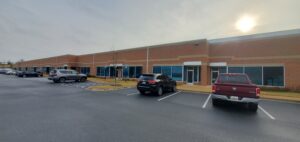 long office building with windows and cars parked in front