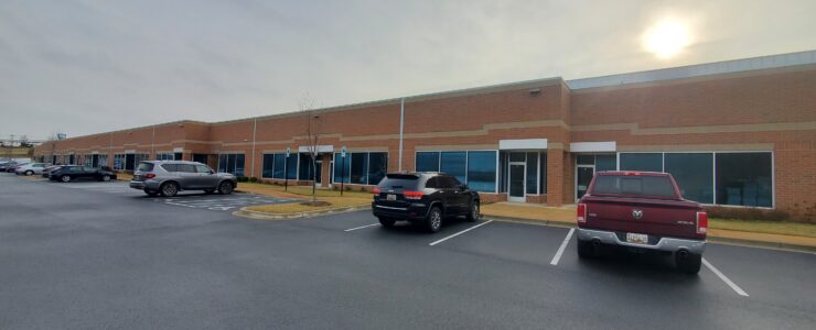 long office building with windows and cars parked in front