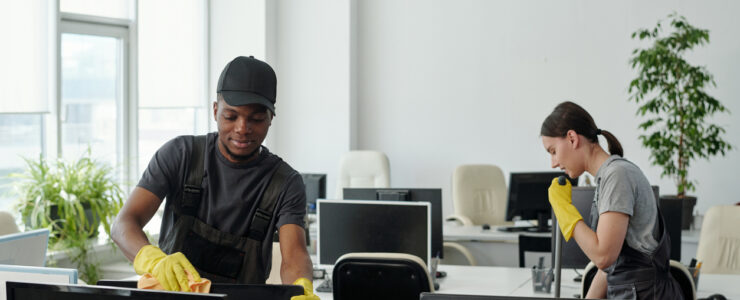 diverse staff of modern commercial cleaning service company wiping computer monitor